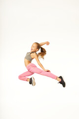Cheerful cute girl in sportswear jumping in studio