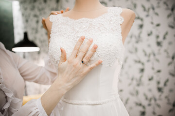 bride's hand on wedding dress in morning room