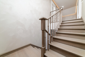 A general view of the handmade wooden oak staircase in the house. Light matte scrawl of wood