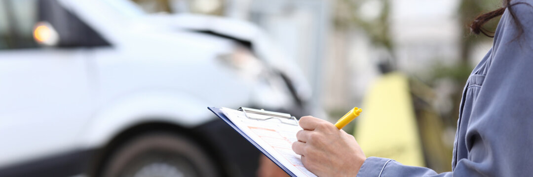 An agent fills out paperwork after car accident. Vehicle insurance concept