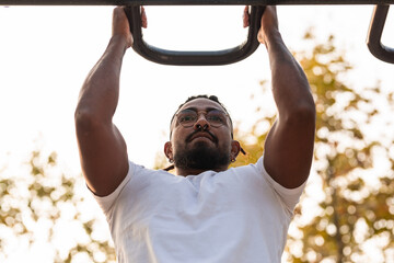 african american athlete doing fitness exercises on bars, calisthenics workout.