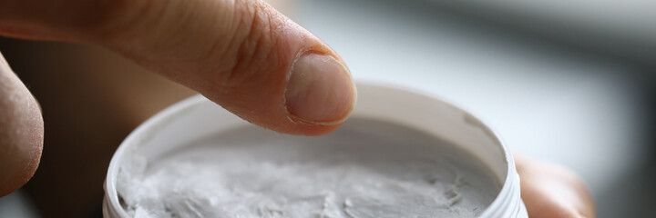 In hands of jar of white cream. Cosmetic products concept