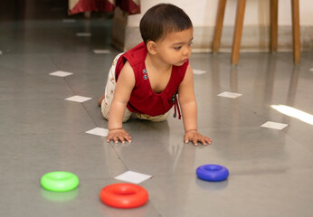 A cute baby Asian Indian baby girl  Adorable toddlers portrait closeup playing with toys. A cute baby girl .