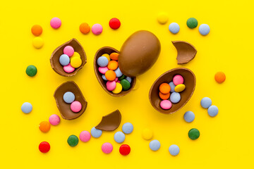 Happy Easter with chocolate eggs and sweets, top view