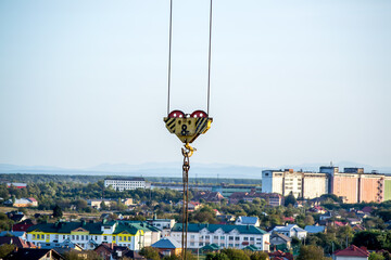High-rise construction site. Lifting mechanism of a construction crane. Block of 8 tons with a hook and steel slings .