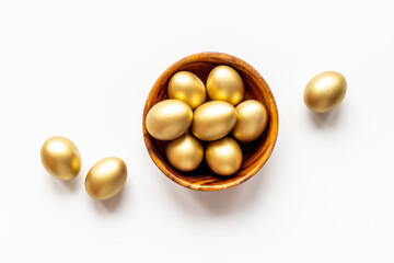 Golden Easter eggs in wooden bowl. Wealth and good luck concept.