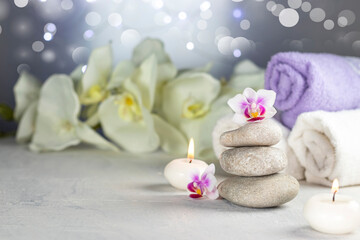 Spa resort therapy composition. Stones, burning candles, towel, abstract lights