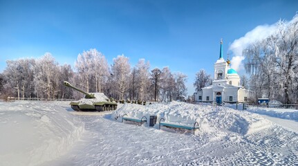 Winter landscape with tank and orthodox church in Russia.