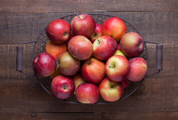 Basket with fresh apples on old rustic wooden table.  Top view.  Flat lay