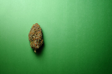 Naklejka premium Marijuana buds closeup. Medicinal cannabis on green background. Hemp recreation, medical usage, legalization.