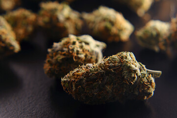 Marijuana buds closeup. Medicinal cannabis on black background. Hemp recreation, medical usage, legalization.