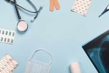 Pills and medical equipment on light blue background. Medicine and healthcare concept. Top view, flat lay, copy space, frame