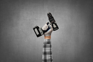 hand holds a construction tool battery (accumulator) drill - perforator
