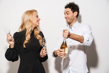 Happy romantic couple smiling while drinking champagne