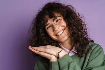 Happy beautiful curly girl smiling and holding her palms together