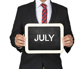  A Businessman holding slate mini blackboard with message July