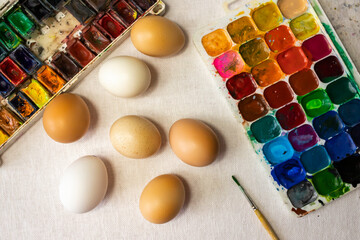 Colorful easter eggs paint and brush on canvas. Easter composition, top view.
