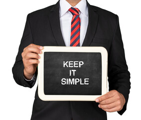 A Businessman holding slate mini blackboard with message Keep it Simple
