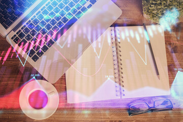 Financial market graph and top view computer on the desktop background. Double exposure. Investment...