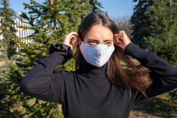 Young woman wears reusable mask outdoors during coronavirus covid-19 pandemic