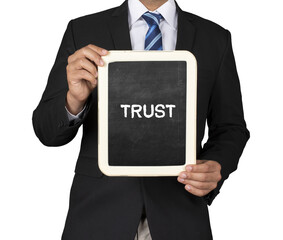 A Businessman holding slate mini blackboard with message Trust