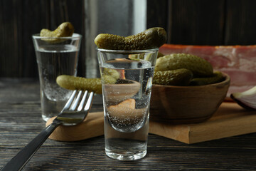 Vodka and tasty snacks on wooden table
