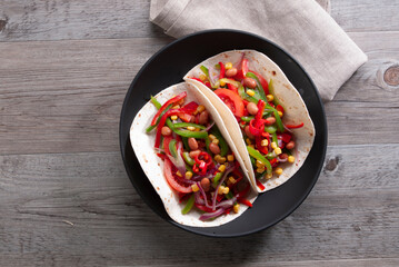 Tacos mejicanos con verduras sobre mesa de madera . Mexican tacos with vegetables on wooden table. © preysler