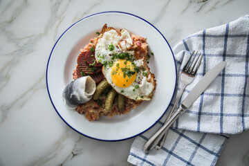 Norddeutscher Hamburger Labskaus mit Rindfleisch Corned Beef, Rote Beete, Kartoffeln, Saure Gurken, Spiegelei und Rollmops auf Emaille Teller