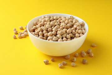 Bowl with fresh chickpea on yellow background