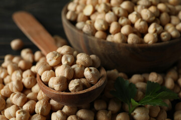 Bowl and spoon with chickpea on wooden table