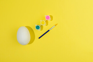 Easter egg painting set. Brush and paint on yellow background
