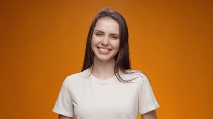 Smiling woman nods her head and says 'yes', approving