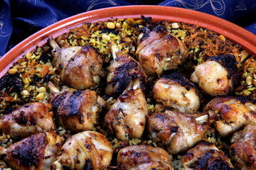 Traditional Tajine Berber Dish Made with Chicken Legs, couscous or rice, blue fabric background
