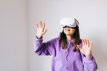 Young smiling caucasian woman using VR headset, gesturing and looking up in virtual reality.