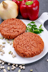 Tasty uncooked burger made with vegetarian plant based imitation minced meat ready for grill