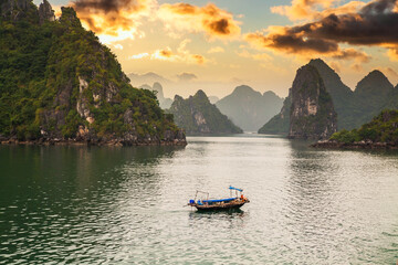 Fototapeta na wymiar View of ships and islands in Halong Bay at sunset, Vietnam.