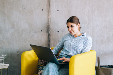 Young woman mobile developer with laptop, writes program code on a computer, programmer work in...