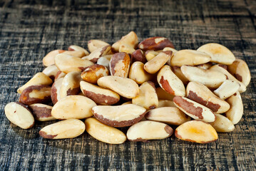 Brazil nut on a black shabby board. Nuts texture on a wooden table.