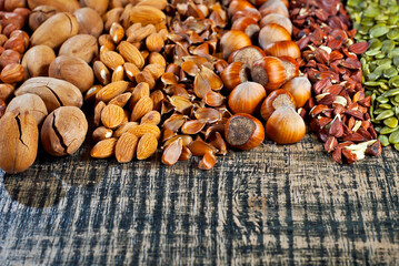 Many kinds of nuts close up. Heap of nuts on a black wooden board. Nuts are stacked on the table.