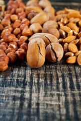 Many kinds of nuts close up. Heap of nuts on a black wooden board. Nuts are stacked on the table.