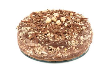 Chocolate creamy cake with chocolate chips and hazelnuts on a glass stand over a white background.