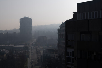 Fototapeta na wymiar Smog lies over the skyline of Historical architecture of Belgrade city. Poor visibility, smog, caused by air pollution. Rooftop view. Emissions of plants and factories. Belgrade, Serbia 25.02.2021