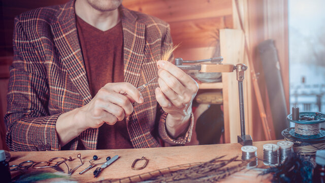 Young Man's Hands Tying A Fly For Fishing