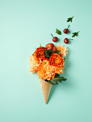Creative layout with beautiful flower bouquet in ice cream cone on pastel green background. Minimal spring bloom or summer art concept. Trendy fashion ice cream floral visual. Flat lay, top view.