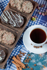 Chocolate and coconut cookies on a wooden board served with a cup of tea