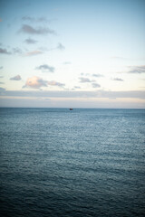Naklejka premium Single boat seen in ocean with clear sky
