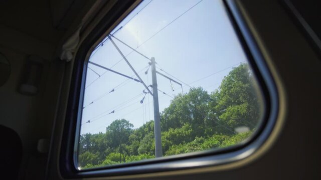 Summer landscape from the window of a speeding train. Railroad running through green fields. Tourist train trip. Fast moving train.