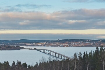 The Vallsundsbron bridge over Lake Storsjön with the city of Östersund in the background just before sunset - 416499428