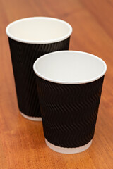 three empty cardboard cups on a wooden background