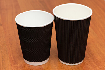 three empty cardboard cups on a wooden background